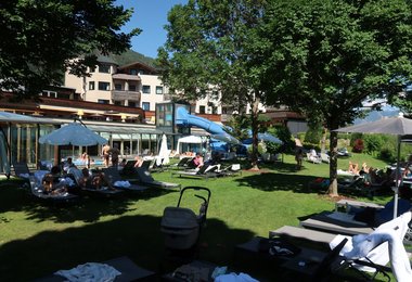 Gartenansicht des Sporthotels Sillian mit beheiztem Außenpool und viel Platz zum Entspannen