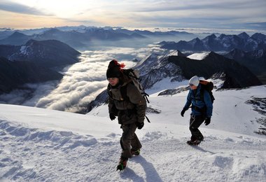 Johannes R. und Lisbeth S, Kinderkrebs-Survivors, ausgerüstet mit Steigeisen, im Schneefeld aufwärts zum Gipfel