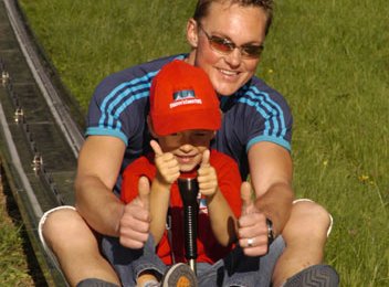 Olympiasieger Alexander Resch mit den Kindern auf der Sommerrodelbahn