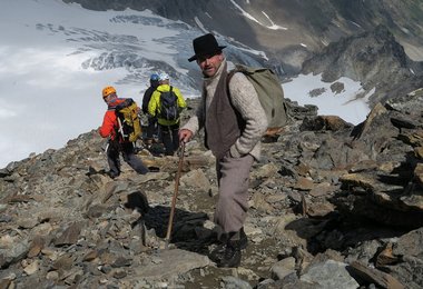 Moderne und historische Bergsteiger beim Abstieg