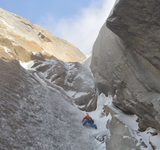 Dani Arnold klettert in der Route "Todo o Nada" am El Mocho. Über ihm die überhängende Schlüsselstelle der Route. Das dünne Eis auf der Felsplatte machte die Kletterei zu einer schwierigeren Angelegenheit als erwartet. (c) visualimpact.ch | Mario Arnold